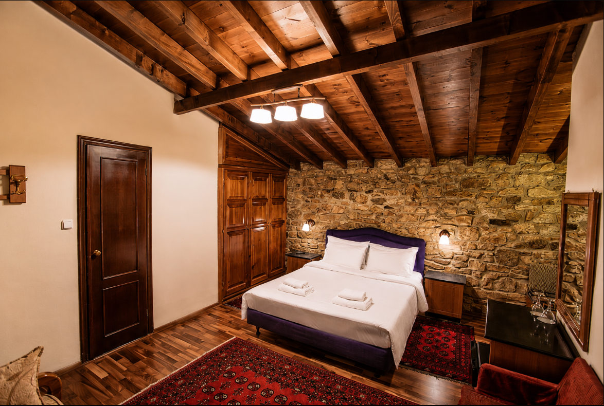 A second guest room at Enterne, showing traditional stonework and quiet, uncluttered furnishings